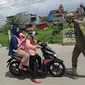 Petugas Satpol PP memberhentikan pengendara motor saat melintasi Pos Pengawasan Larangan Mudik di Cigombong, Bogor, Rabu (29/4/2020). Polres Bogor terus melakukan penyekatan  mencegat pemudik sekaligus PSBB mengantsipasi penyebaran virus Covid-19. (merdeka.com/Arie Basuki)