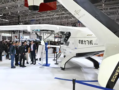 Pengunjung terlihat di samping pesawat Zerog eVTOL model ZG-T6 di stan Zerog selama Aero Asia 2025 di Zhuhai, Provinsi Guangdong, Tiongkok selatan, pada Kamis 27 November 2025. Pameran penerbangan dan kedirgantaraan internasional Aero Asia 2025 resmi dibuka. (Hector RETAMAL/AFP)