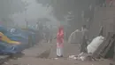 Petugas kebersihan menyapu jalan di ibu kota India, New Delhi yang diselimuti kabut asap, Rabu (8/11). Indian Medical Association menyarankan warga untuk tidak keluar rumah dan menghindari sedapat mungkin aktivitas fisik apapun. (SAJJAD HUSSAIN/AFP)