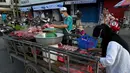 Pedagang menyiapkan daging untuk dijual di sepanjang jalan karena pasar tetap tutup di tengah pembatasan lockdown yang diberlakukan untuk mencoba menghentikan lonjakan kasus virus corona COVID-19 di Phnom Penh, Kamboja, Selasa (11/5/2021). (TANG CHHIN Sothy/AFP)