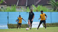 Dalberto Luan (tengah) dikawal Rifad Marasabessy dalam sesi latihan Arema di lapangan ARG, Kabupaten Malang. (Bola.com/Iwan Setiawan)
