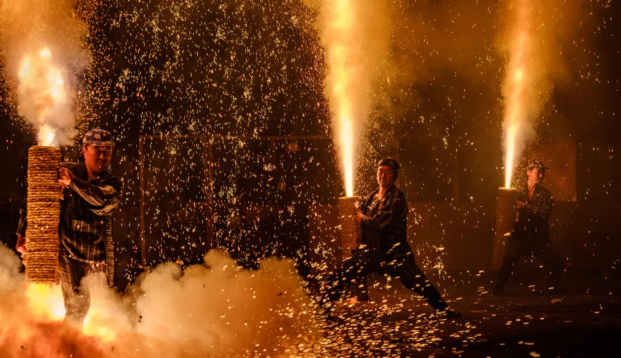 Sejumlah pria memegang Tezutsu hanabi atau kembang api genggam pada malam Festival Toyohashi Gion di Toyohashi, Jepang, Jumat (20/7). Acara tahunan ini diikuti oleh setiap anggota laki-laki untuk Kuil Yoshida. (Yasuyoshi CHIBA/AFP)