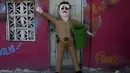 Boneka raja narkoba Joaquin "El Chapo" Guzman yang sudah selesai dikerjakan terlihat di depan pintu di Reynosa, Meksiko (21/7/2015). Guzman melarikan diri dari penjara melalui terowongan yang ia buat pada bulan lalu. (REUTERS/Daniel Becerril)