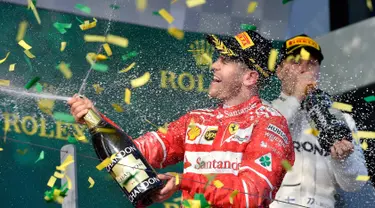 Pembalap Ferrari, Sebastian Vettel menyemprotkan sampanye di atas podium setelah berhasil memenangi balapan GP Australia di Sirkuit Albert Park, Melbourne, Minggu (26/3). Vettel sukses mengasapi rival utamanya Lewis Hamilton. (AP Photo/Andy Brownbill)