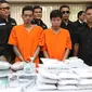 Petugas menunjukkan barang bukti beserta tersangka kasus penyelundupan ekstasi di Mabes Polri, Jakarta, Selasa (1/8). Polri dan Bea Cukai mengungkap penyelundupan 1,2 juta butir ekstasi dari Belanda senilai Rp600 miliar. (Liputan6.com/Immanuel Antonius)