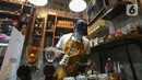 Barista membuat kopi di kedai Ngopi di Halaman Jalan Pulo Kamboja, Kebayoran Lama, Jakarta, Selasa (12/01/2021). Kedai yang buka pada hari Selasa - Minggu dari pukul 10.00 - 22.00 WIB juga menawarkan koleksi buku fotografi yang dibaca di tempat. (Liputan6.com/Fery Pradolo)