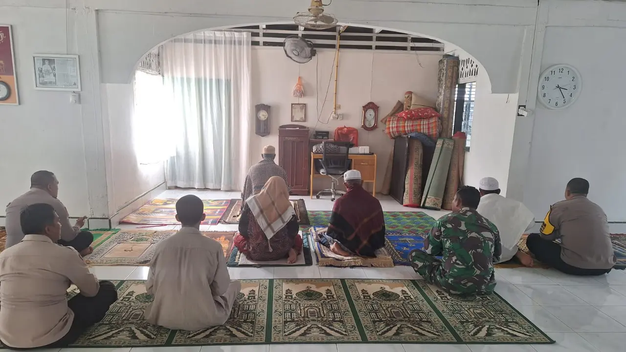Personel Polsek di Rokan Hulu mendekati tokoh tasawuf di sebuah surau untuk sosialisasi Pilkada damai.
