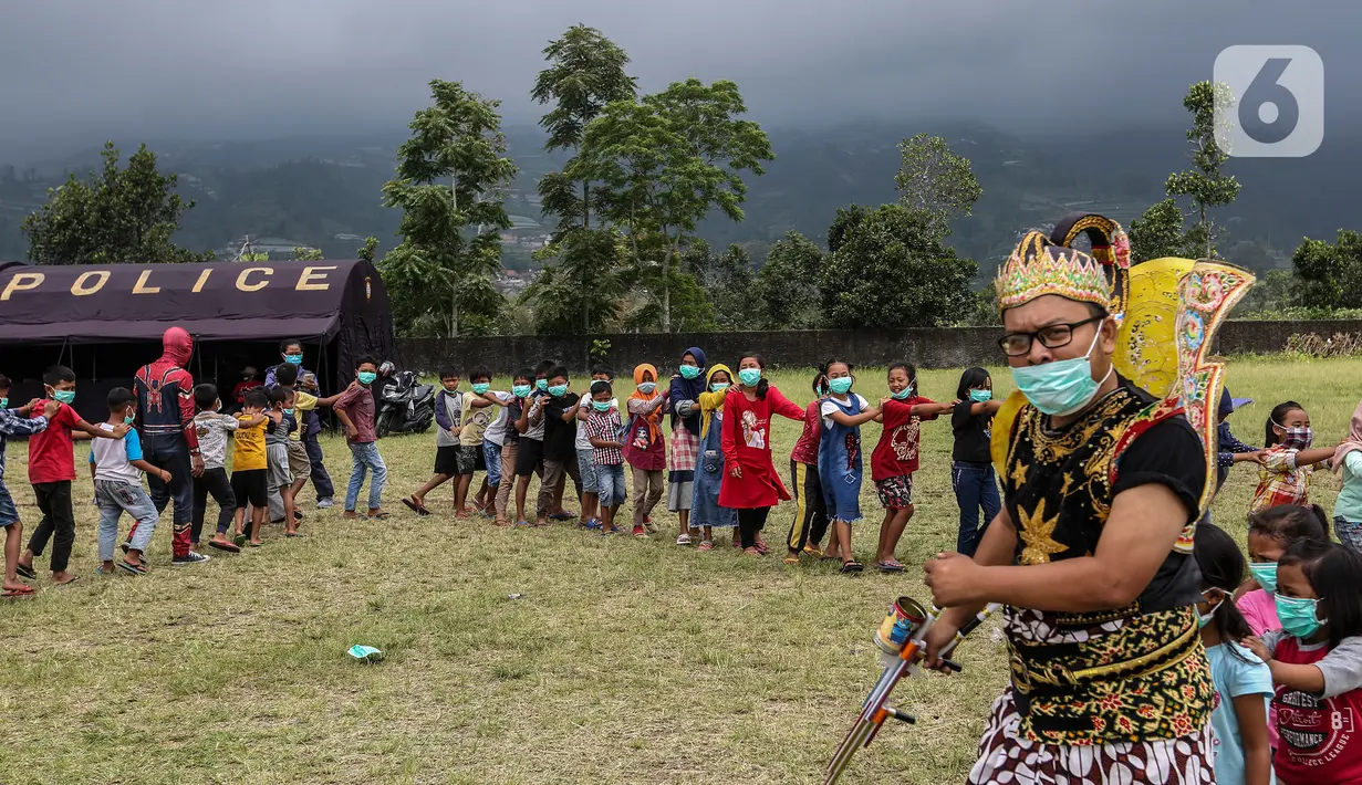Anak-anak saat bermain dengan relawan berkostum superhero di Tempat Pengungsian Gunung Merapi, Desa Klakah, Selo, Boyolali, Jawa Tengah, Sabtu (21/11/2020). Kegiatan bermain ini untuk mengisi waktu anak-anak sehingga dapat menjaga kondisi anak tetap ceria dan sehat. (Liputan6.com/Johan Tallo)