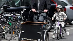 Seorang anak mengendarai sepeda di sebuah jalan di Wina, Austria, (13/5/2020). Menurut Transport Club Austrian, semakin banyak warga Wina memilih bepergian menggunakan sepeda selama pandemi. (Xinhua/Guo Chen)
