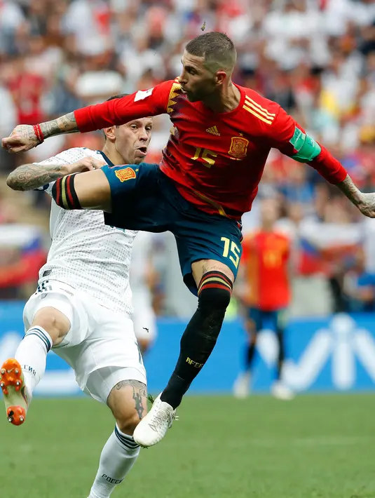 Pemain timnas Spanyol, Sergio Ramos berebut bola dengan pemain Rusia, Fyodor Kudryashov pada babak 16 besar Piala Dunia 2018 di Stadion Luzhniki, Minggu (1/7). Rusia lolos ke perempat final setelah menang adu penalti 4-3 atas Spanyol. (AP/Antonio Calanni)