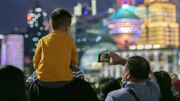 Orang-orang menikmati pertunjukan cahaya di Bund, Shanghai, China timur, pada 5 Oktober 2020, hari kelima libur Hari Nasional dan Festival Pertengahan Musim Gugur. (Xinhua/Wang Xiang)