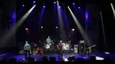 Grup rock Eagles of Death Metal tampil di atas panggung gedung teater Olympia, Paris, Selasa (16/2). Grup rock asal California itu menggelar konser di hadapan ratusan penggemar yang selamat dari serangan teror pada November lalu. (AFP PHOTO/Joel SAGET)