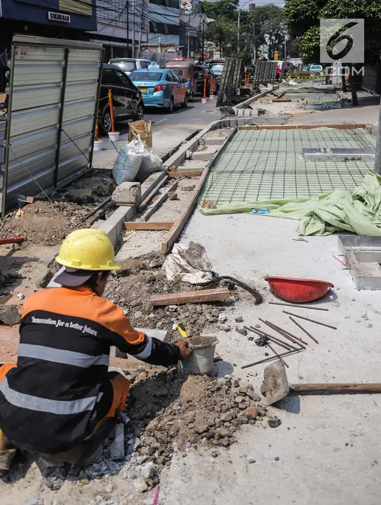 Pekerja menyelesaikan proyek revitaslisasi trotoar di kawasan Cikini, Jakarta, Senin (1/7/2019). Revitalisasi trotoar di kawasan Cikini hingga Kramat ditargetkan rampung pada Desember 2019. (Liputan6.com/Faizal Fanani)