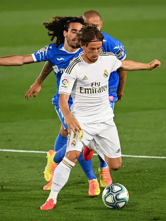 Gelandang Real Madrid,  Luka Modric mengontrol bola dari kawalan bek Getafe, Marc Cucurella pada pertandingan lanjutan La Liga Spanyol di stadion Alfredo di Stefano di Valdebebas, Madrid (2/7/2020). Madrid menang tipis atas Getafe 1-0.  (AFP Photo/Gabriel Bouys)