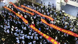 Sejumlah siswa berbaris sambil membentengkan spanduk saat melukan parade untuk menghilangkan stres jelang ujian tahunan "Gaokao" di Haikou, China (4/6). (AFP)
