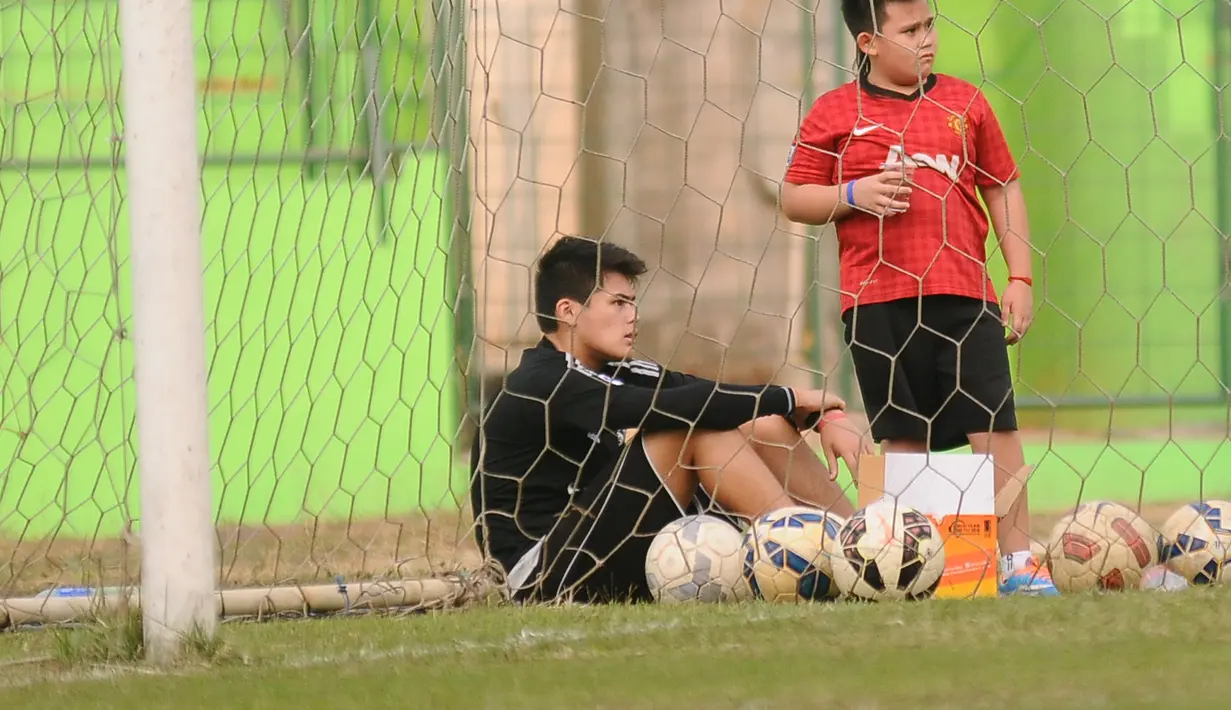 Dua anak Cristian Gonzales, Michael Gonzales (kiri) dan Fernando Gonzales, memperhatikan ayahnya berlatih bersama tim Arema Cronus di Stadion Gajayana, Malang, Jumat (30/10/2015). (Bola.com/Kevin Setiawan)