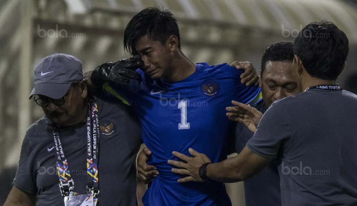 2. Kiper Timnas Indonesia, Satria Tama, menangis karena mengalami cedera saat melawan Vietnam, dirinya kemudian diganti oleh Kurniawan Kartika Ajie. (Bola.com/Vitalis Yogi Trisna)