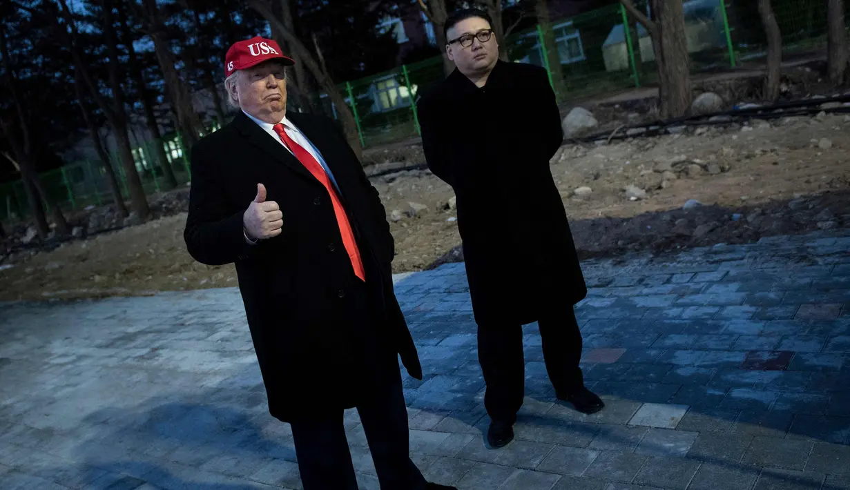 Dua pria berpakaian seperti pemimpin Korea Utara Kim Jong Un dan Presiden AS, Donald Trump bersiap menghadiri upacara pembukaan Olimpiade Pyeongchang 2018 di Pyeongchang, Korea Selatan (9/2). (AFP Photo/Brendan Smialowski)