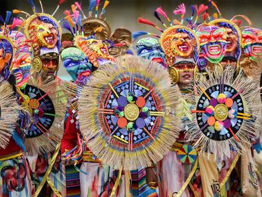 Peserta mengenakan kostum dan riasan berpose saat mengikuti parade Canto a la Tierra di Pasto, Kolombia (3/1). Parade Canto a la Tierra juga dikenal dengan karnaval orang kulit hitam dan kulit putih di Pasto. (AFP Photo/Luis Robayo)