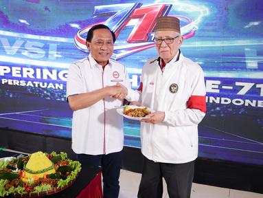 Ketua Umum Persatuan Bola Voli Seluruh Indonesia (PBVSI), Imam Sudjarwo (kiri) memberikan potongan tumpeng pertama kepada Purnama S. Yamil pada perayaan hari ulang tahun ke-71 yang dilaksanakan di Gedung Serbaguna Padepokan Voli Sentul, Kamis (26/2/2026) sore WIB. (Bola.com/Abdul Aziz)