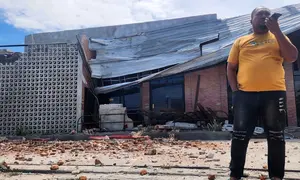 Seorang pria berbicara di telepon selulernya di dekat sebuah bangunan yang rusak akibat gempa di Palu, Sulawesi Tengah, Selasa 16 Juni 2026. (AP Photo/Josua Marunduh)