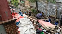 Anggota Pemadam Kebakaran Kota Depok menemukan ular saat evakuasi rumah longsor di RT 4/9, Kelurahan Cilangkap, Kecamatan Tapos, Kota Depok. (Istimewa)