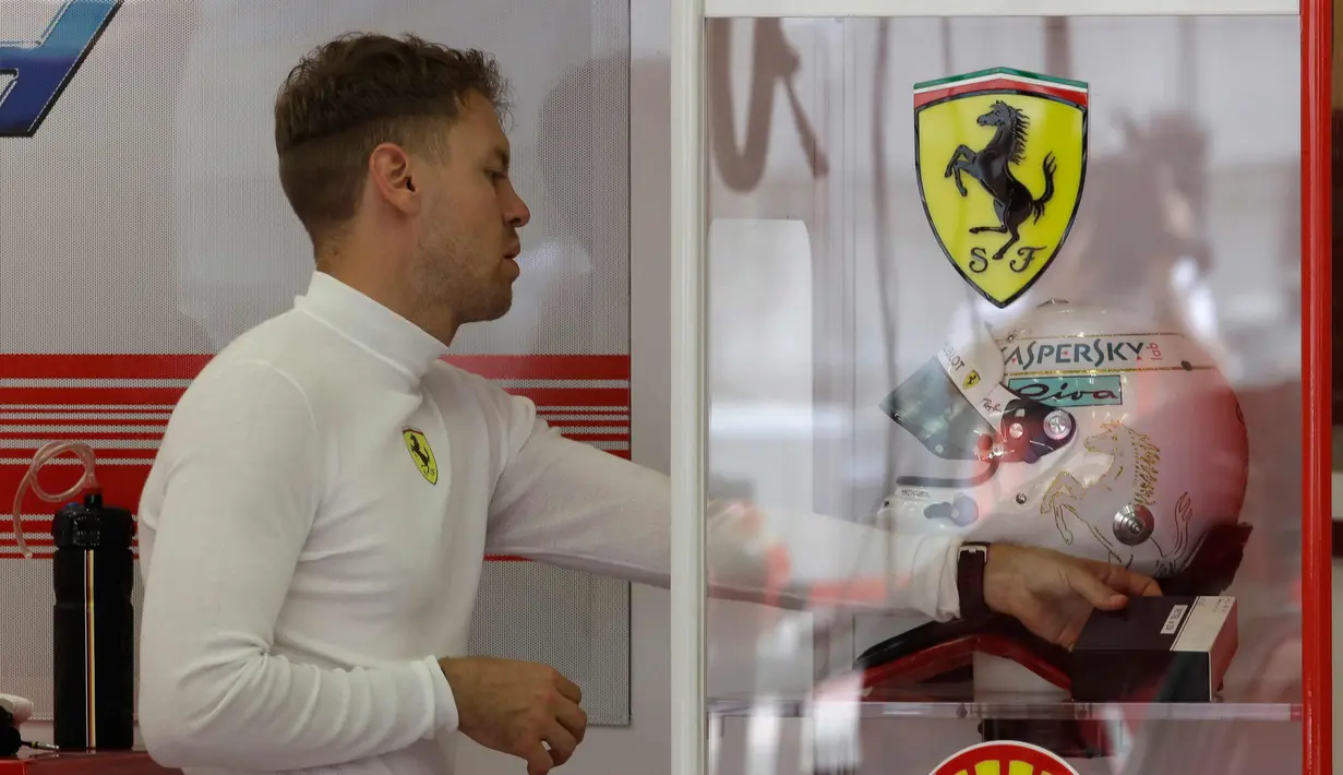 Pembalap Ferrari Sebastian Vettel dari Jerman bersiap di pit selama latihan bebas pertama di Sirkuit Internasional Bahrain Formula Satu di Sakhir, Bahrain, (5/4). F1 GP Bahrain akan berlangsung pada hari Minggu. (AP Photo/Luca Bruno)