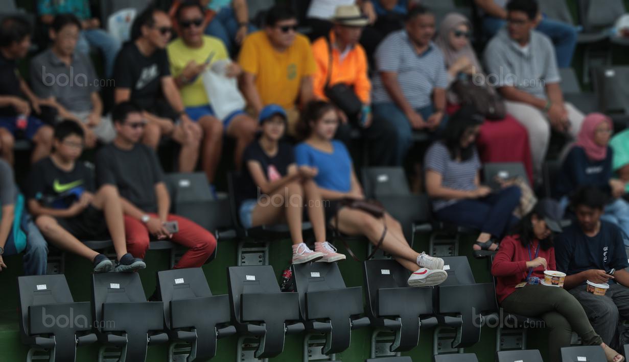 Aksi sejumlah penonton mengangkat kaki pada sandaran kursi saat laga Piala Davis 2018 grup dua Asia/Oceania di Senayan, Jakarta, Sabtu (4/2/2018). Renovasi Lapangan Tenis ini memakan biaya sekitar 92 miliar rupiah.  (Bola.com/Nick Hanoatubun)