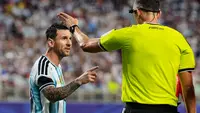 Lionel Messi dari Argentina, kiri, berbicara dengan wasit Joao Pinheiro, dari Portugal, saat pertandingan perempat final Piala Dunia 2026 melawan Swiss di Kansas City, Mo., Minggu, 12 Juli 2026. (AP Photo/Charlie Riedel)