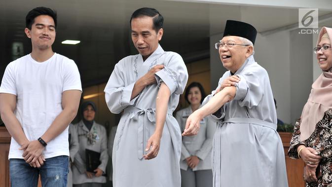 Bakal calon presiden dan wakil presiden Joko Widodo atau Jokowi (dua kiri) dan KH Ma'ruf Amin (dua kanan) menunjukkan tangan mereka sebelum tes kesehatan di RSPAD Gatot Subroto, Jakarta, Minggu (12/8). (Merdeka.com/Iqbal Nugroho)
