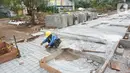 Pekerja menyelesaikan proyek revitalisasi trotoar di kawasan Kemang, Jakarta, Kamis (31/10/2019). Revitalisasi trotoar Kemang yang ditargetkan rampung pada November 2019 ini untuk memaksimalkan kenyamanan pejalan kaki dan mendongkrak aktivitas ekonomi di kawasan tersebut. (Liputan6.com/Angga Yuniar)