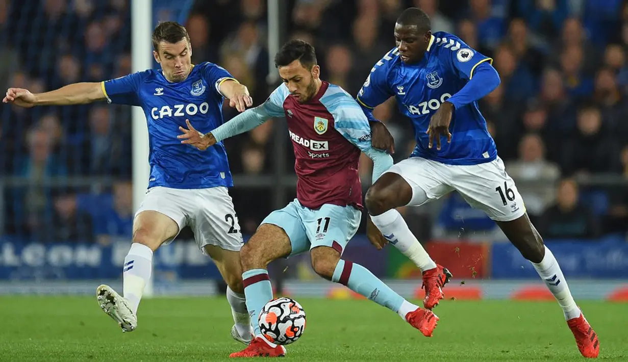 Pemain Burnley Dwight McNeil (tengah) berebut bola dengan pemain Everton Seamus Coleman (kiri) dan Abdoulaye Doucoure (kanan) pada pertandingan Liga Inggris di Goodison Park, Liverpool, Inggris, 13 September 2021. Everton menang 3-1. (Oli SCARFF/AFP)