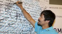 Petinju Filipina Manny Pacquiao menandatangani namanya di papan Calon Integritas usai pengajuan Sertifikat Pencalonan Senator di Mei 2016 pemilihan nasional, di Komisi Pemilihan Umum ,Manila, Filipina (16/10/2015). (REUTERS/Erik De Castro)