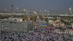Umat Muslim berjalan menuju bukit berbatu yang dikenal sebagai Jabal Rahmah atau Gunung Rahmat, di Dataran Arafah, selama ibadah haji tahunan di dekat kota suci Mekah, Arab Saudi, Selasa 26 Mei 2026. (AP Photo/Altaf Qadri)
