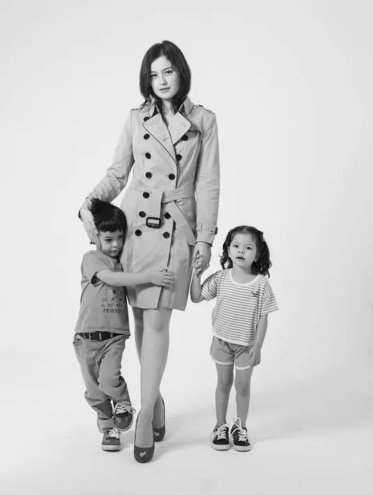 Di foto lainnya, masih dalam nuansa hitam-putih, Kimberly tampil dengan trench coat dan high heels, menggandeng kedua anaknya yang tampil dengan outfit kasual. [Foto: Instagram/blekribe]