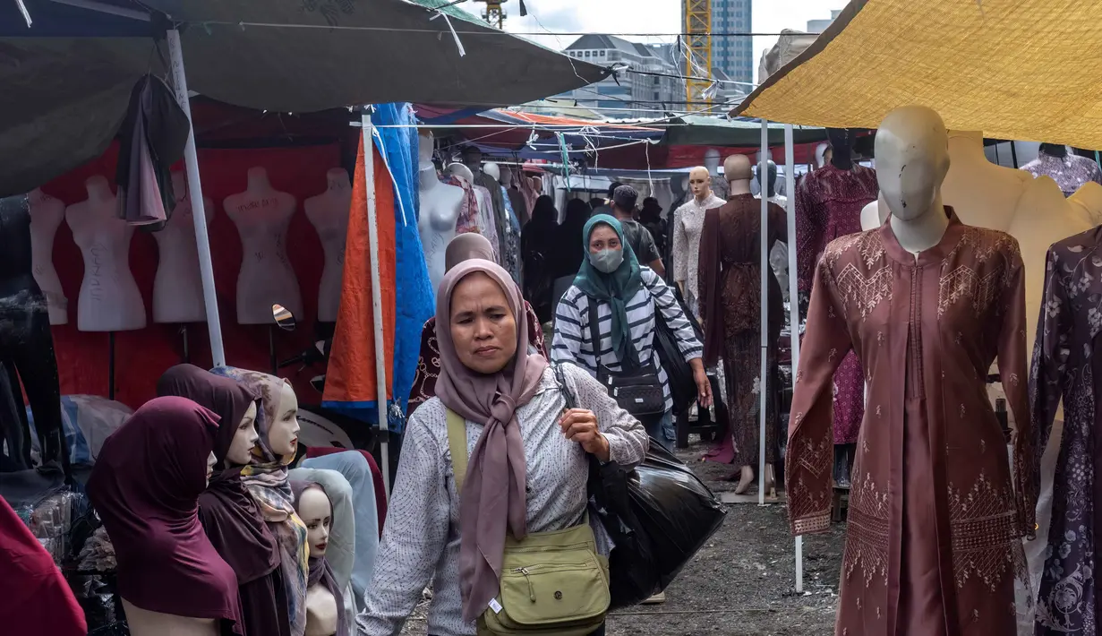 Langkah dinilai banyak pihak menjadi titik balik bagi kebangkitan industri tekstil nasional. Tampak dalam foto, pembeli berjalan di antara kios-kios penjual pakaian lokal di salah satu pasar tradisional, Jakarta, Kamis 20 November 2025. (BAY ISMOYO/AFP)