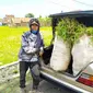 Muhamad Syam, menunjukan barang bawannya berupa rumput di mobil sedan e 300 classic tunggannya. (Liputan6.com/Jayadi Supriadin)