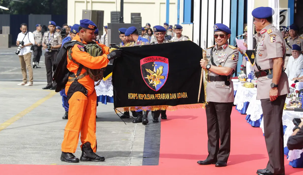 Kapolri Jenderal Pol Tito Karnavian memberikan bendera Korps Polisi Air dan Udara pada peringatan HUT ke-67 Polairud di Lapangan Udara Pondok Cabe, Tangsel, Selasa (5/12). Dalam peringatan ini, berbagai atraksi ditampilkan. (Liputan6.com/Faizal Fanani)