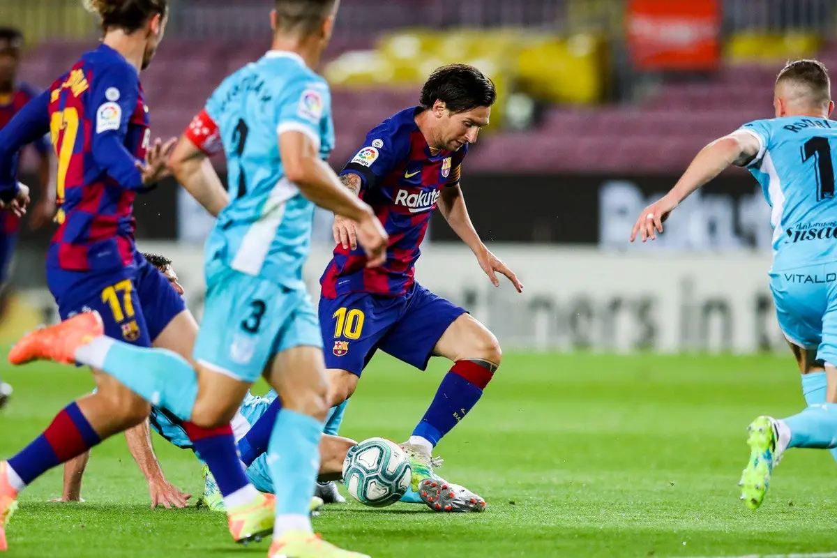 Penyerang Barcelona, Lionel Messi, saat mencoba lepas dari kawalan pemain Leganes
