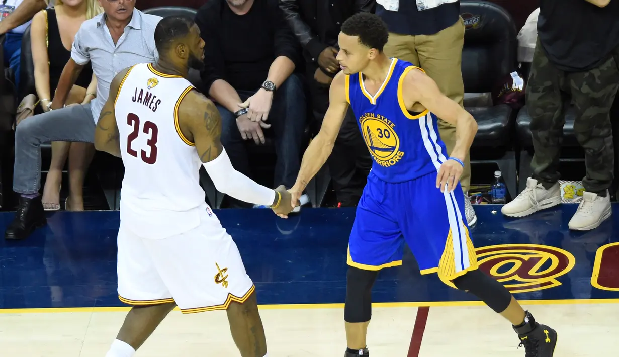 Pemain Warriors, Stephen Curry (kanan) bersalaman dengan LeBron James usai pertandingan ke enam final NBA di Quicken Loans Arena,  Cleveland, (17/6/2015). Warriors menang 105-97 pada pertandingan ke enam final NBA. (Reuters/Ken Blaze)