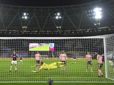 Pemain West Ham United Issa Diop (kanan) mencetak gol ke gawang Sheffield United pada pertandingan Liga Inggris di London Stadium, London, Inggris, Senin (15/2/2021). West Ham United menang 3-0. (Glyn Kirk/Pool via AP)