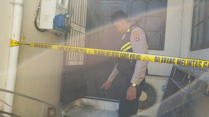 Polisi menunjuk bekas terbakar akibat lemparan bom molotov ke Gereja Toraja di Makassar (Liputan6.com/ Eka Hakim)