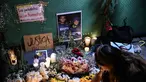 Seorang wanita meletakkan lilin di altar sebagai penghormatan bagi jurnalis yang tewas akibat serangan Israel di Jalur Gaza, saat menghadiri doa bersama di Mexico City pada 12 Agustus 2025. (Yuri CORTEZ/AFP)