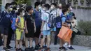 Siswa sekolah dasar mengenakan masker untuk melindungi diri dari penyebaran COVID-19 dan menunggu di luar gerbang sekolah di Taipei, Taiwan, Rabu (1/9/2021). Seluruh sekolah di Taiwan kembali dibuka untuk tahun ajaran baru setelah ditutup akibat pandemi COVID-19. (AP Photo/Chiang Ying-ying)