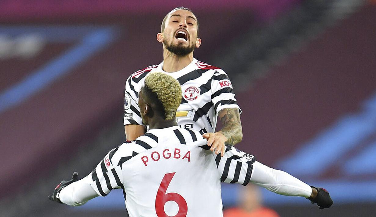 Pemain Manchester United, Paul Pogba, melakukan selebrasi bersama Alex Telles usai mencetak gol ke gawang West Ham United pada laga Liga Inggris di Stadion London, Minggu (6/12/2020). Setan Merah menang dengan skor 1-3. (Justin Setterfield/Pool Via AP)