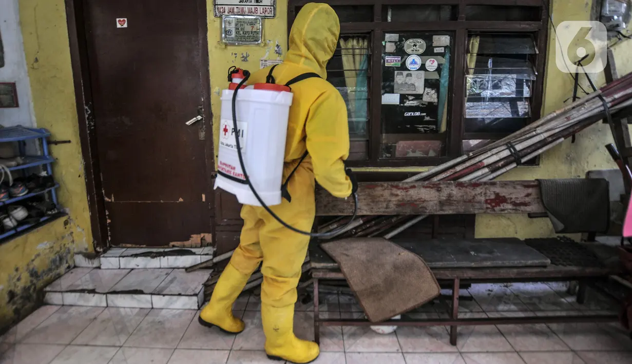 Petugas PPSU menyemprotkan disinfektan di depan salah satu rumah warga yang terpapar COVID-19 saat pemberlakuan karantina wilayah skala kecil atau mini lockdown di RT 011 RW 009, Kelurahan Kayu Putih, Pulogadung, Jakarta Timur, Minggu (6/6/2021). (merdeka.com/Iqbal S. Nugroho)