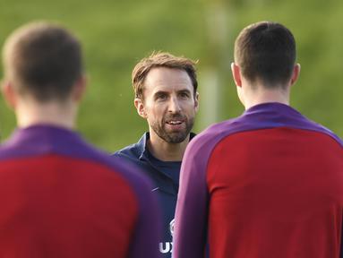 Pelatih sementara timnas Inggris, Gareth Southgate (tengah) saat berbincang dengan para pemain pada sesi latihan persiapan melawan Malta di St George's Park,  Burton-upon-Trent, (4/10/2016). AFP/Paul Ellis)