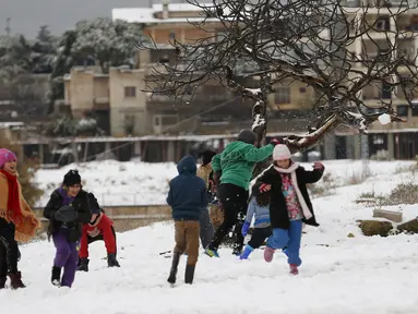 Sejumlah anak pengungsi Suriah bermain dengan salju di Aley, Lebanon, Jumat (1/12/2016). Badai salju di Lebanon menambah kesengsaraan puluhan ribu pengungsi Suriah yang tinggal di tempat penampungan sementara wilayah tersebut. (REUTERS/Jamal Saidi)
