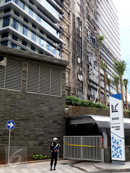 Petugas keamanan gedung berjaga di dekat Gedung Neo Soho pasca kebakaran di Tanjung Duren, Jakarta, Kamis (10/11). Hingga kini penyebab kebakaran belum diketahui dan masih dalam tahap penyelidikan. (Liputan6.com/Gempur M. Surya)