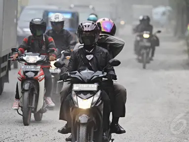 Pengendara melintasi jalan yang dipenuhi debu tebal di Jalan Kemukus, Tamansari, Jakarta Barat, Senin (24/11/2014). (Liputan6.com/Faizal Fanani)